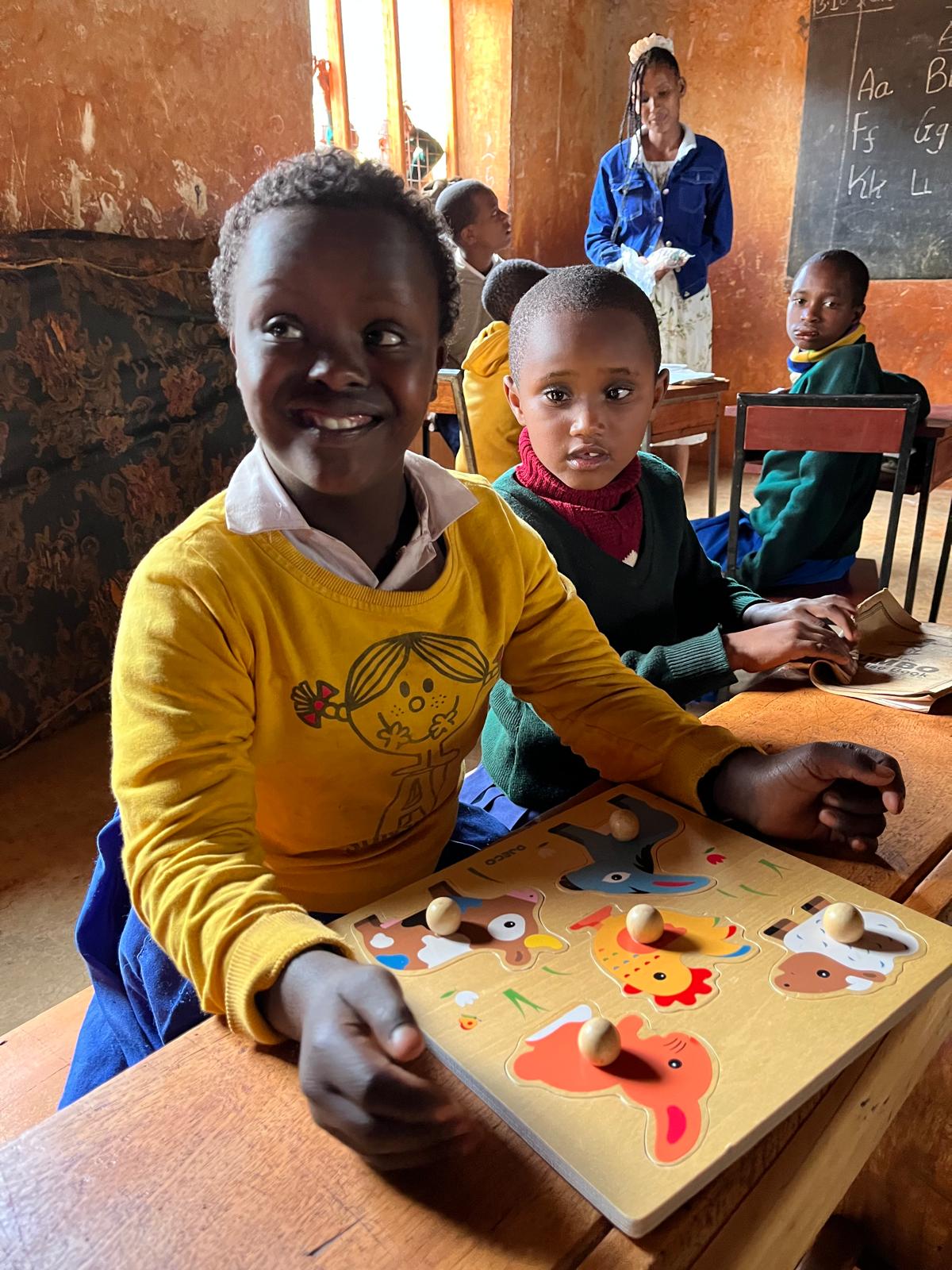 Kind mit Lernpuzzle im Klassenraum in Dareda